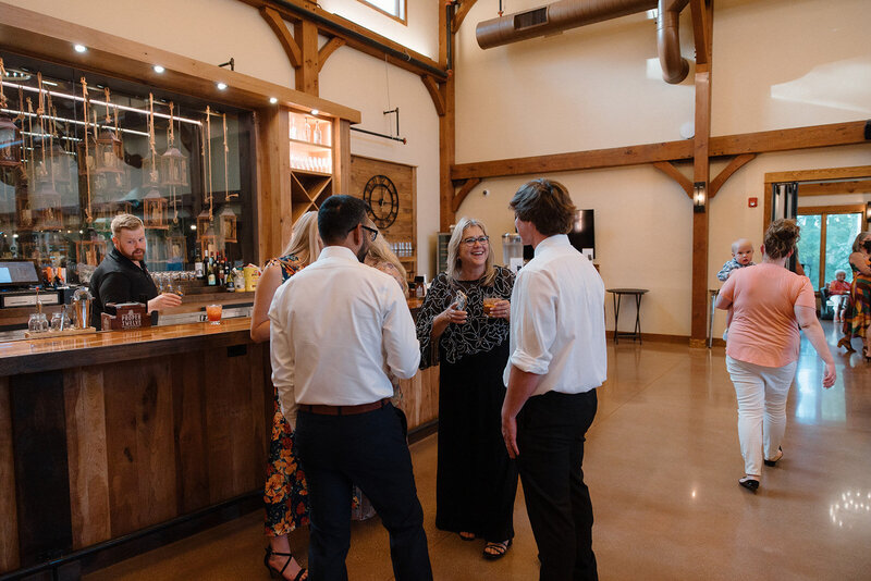 guests chitchating in the barn at barnwood events, a wedding venue in madison, winconsin.