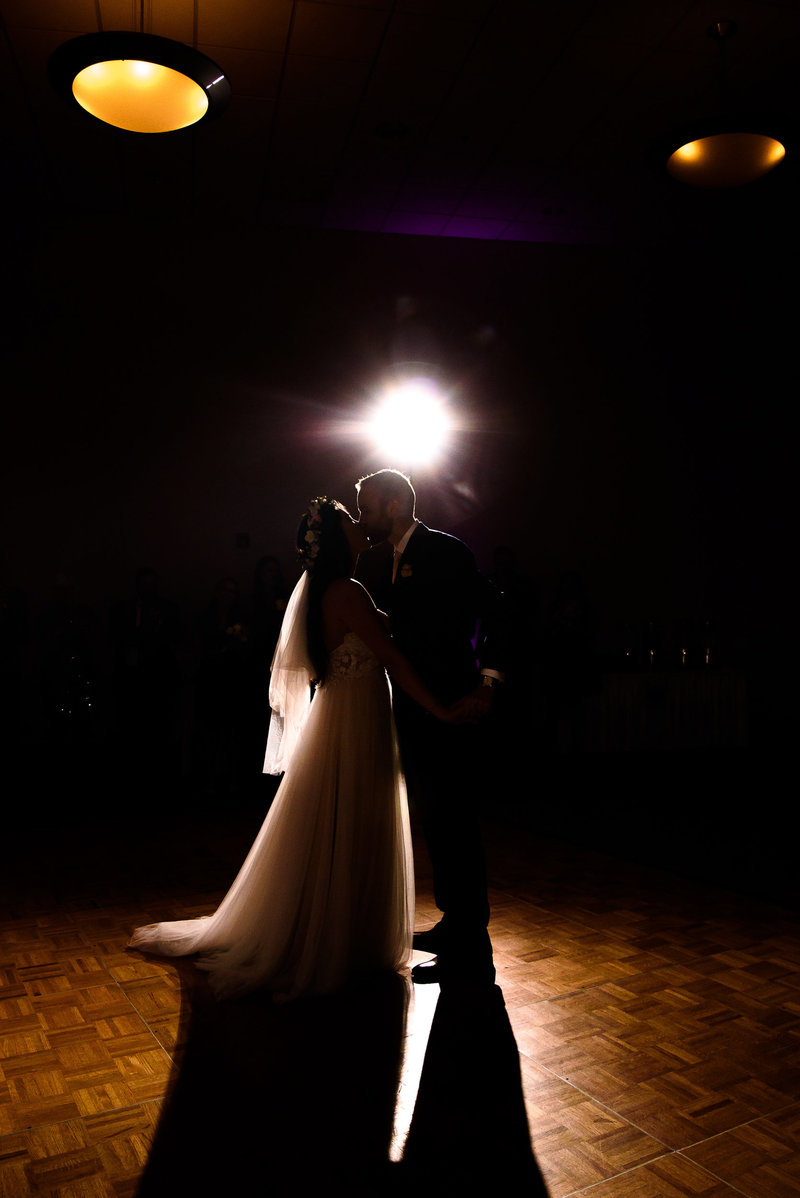 Backlit picture of a final kiss at the end of a first dance