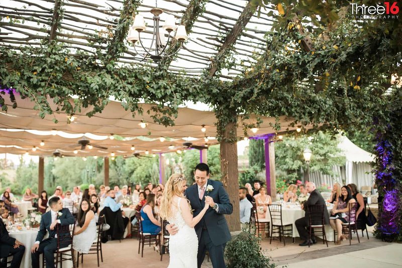 Bride and Groom share their first dance in front of wedding guests at the Europa Village wedding venue