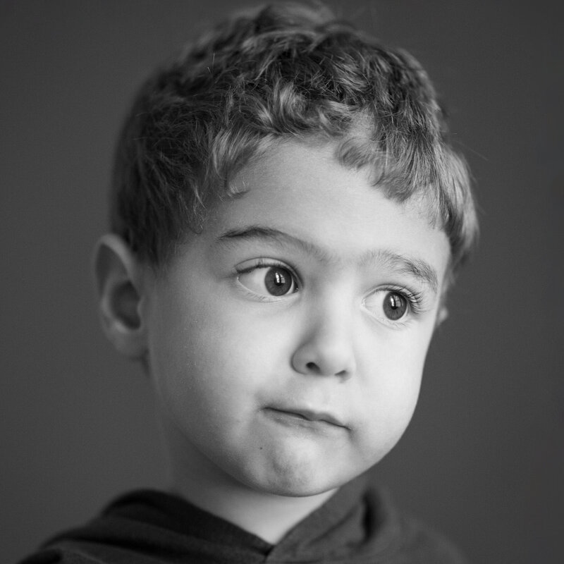 Small boy making a silly face in a studio photo in black and white