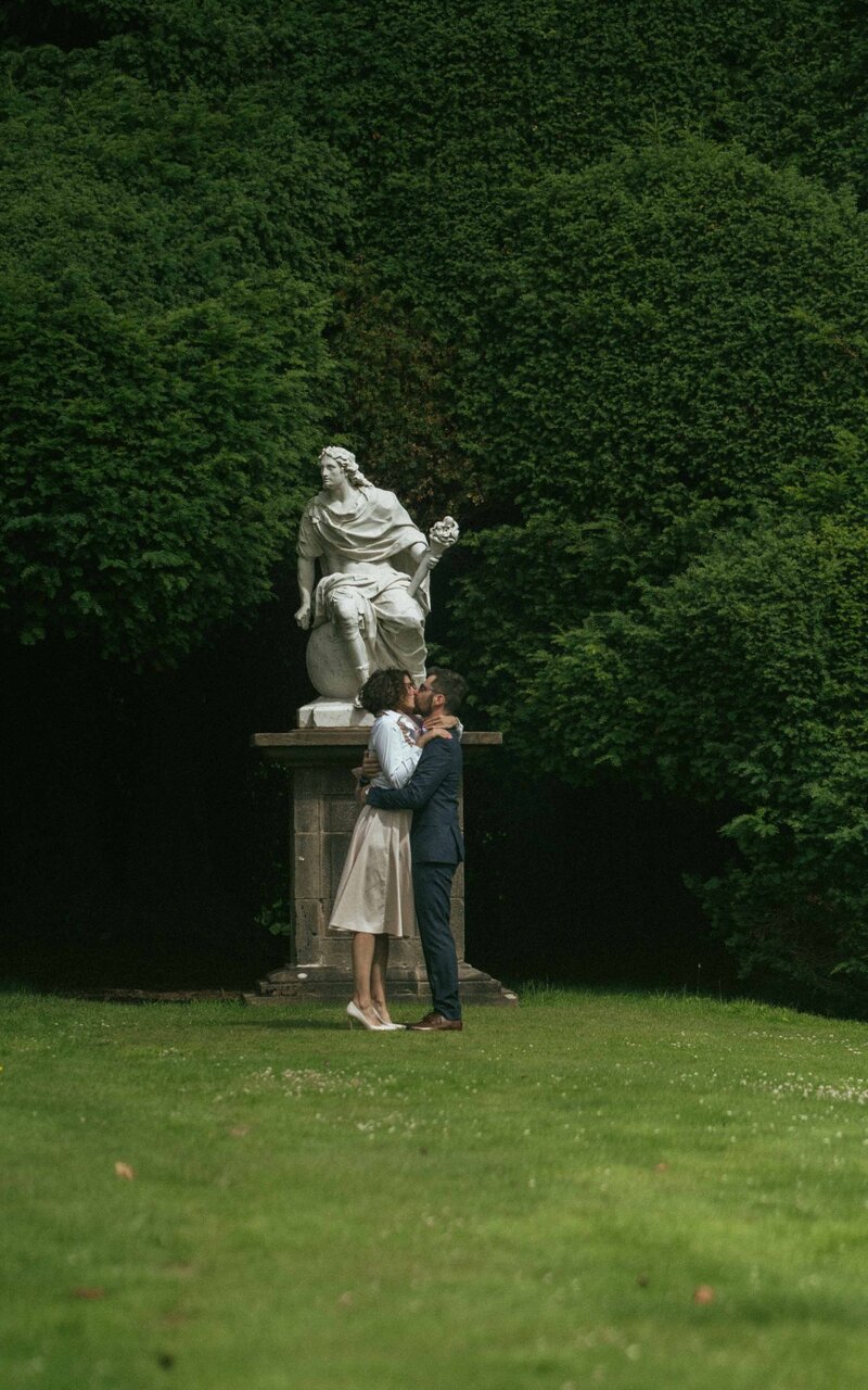 Romantic kiss between a couple standing in a beautiful garden, capturing an intimate moment of love and connection in a serene, natural setting