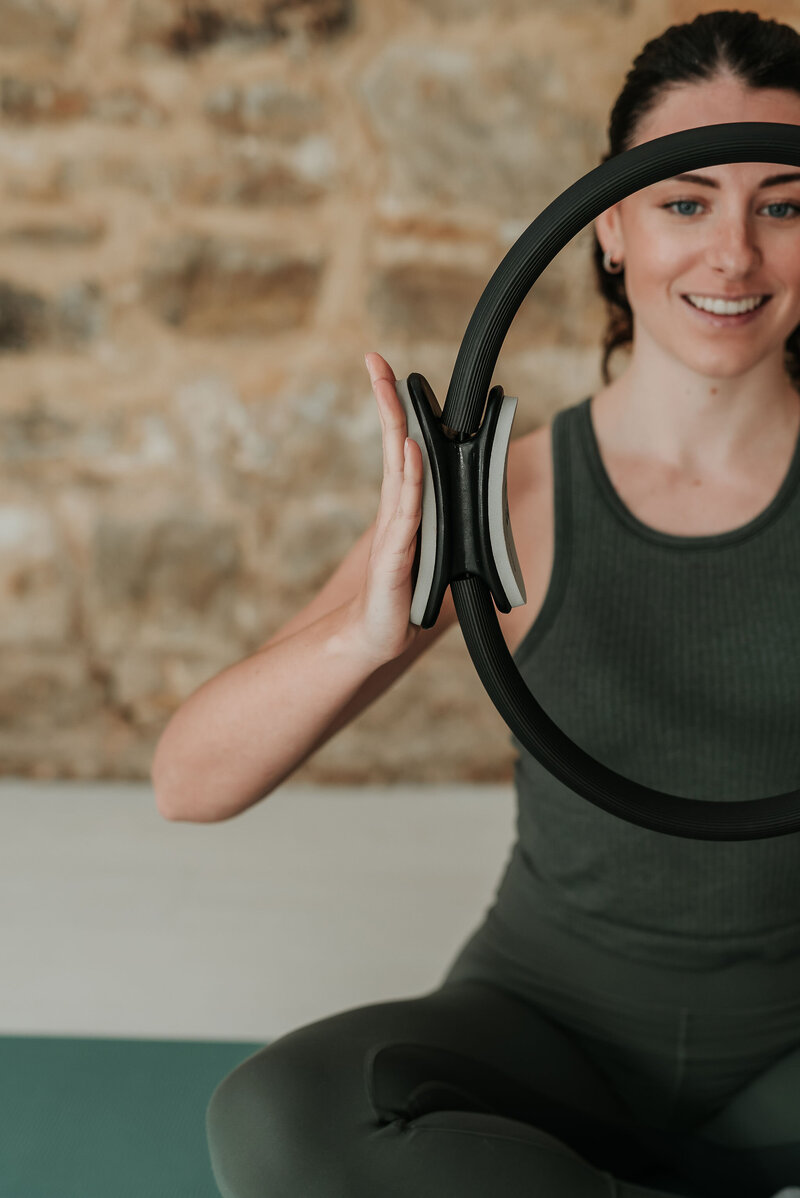 Close up of female pilates instructor using a pilates resistance circle