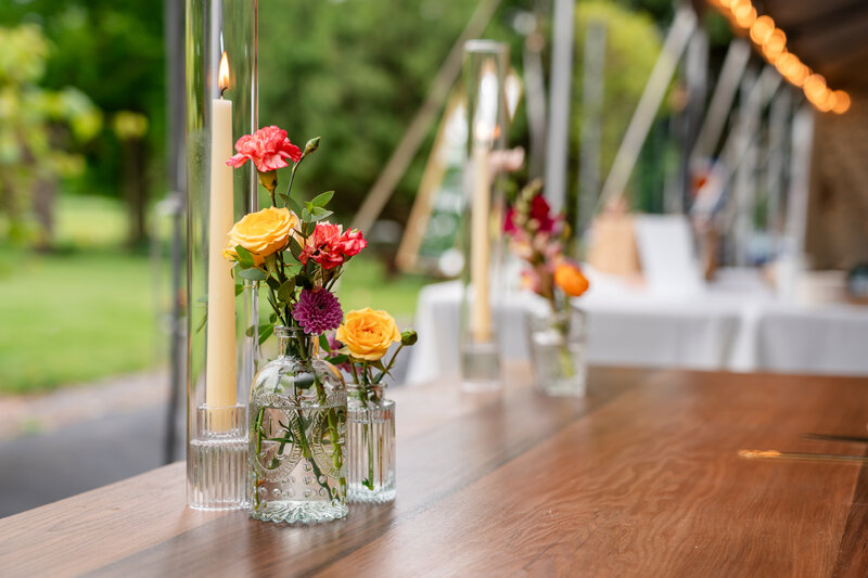 Colorful floral vases displayed on railing with bright summer blooms – photographed by wedding photographer Niko Coric – Lumen Clarity Media