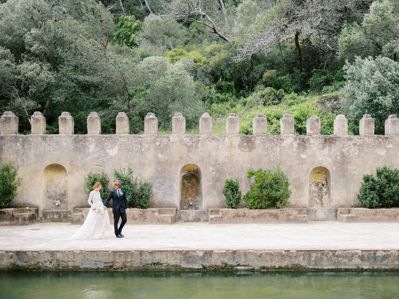 bride and groom walk at gardens at penha longa resort in sintra, portugal