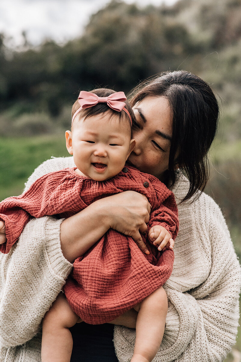 photo of asian mother holding baby