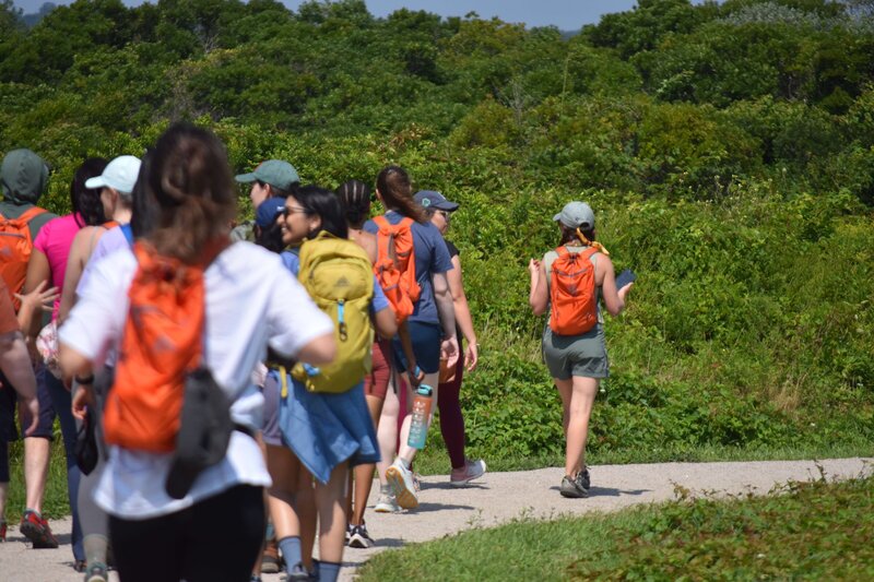 Meredith Ewenson leading a group hike in Rhode Island at Sachuest Wildlife Refuge in Middletown with the Rhode Island Hiking Collective with everyone wearing Gregory Packs