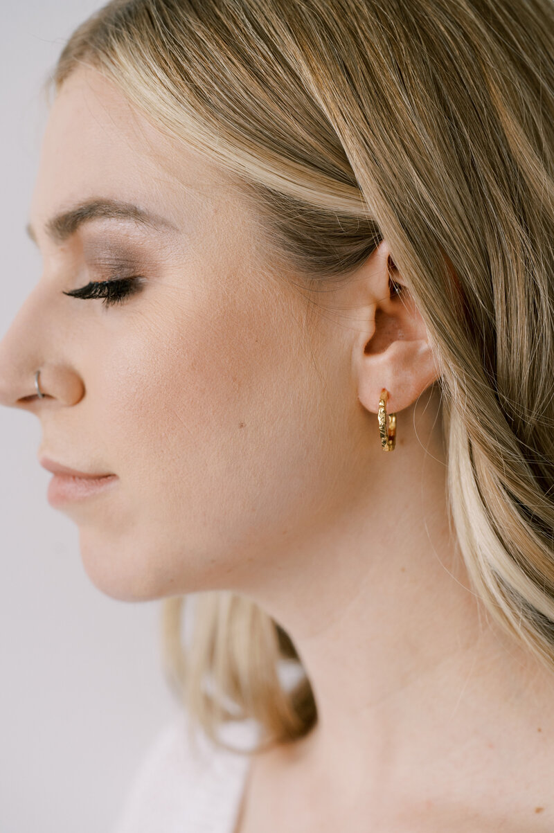 Upclose of woman wearing gold earrings