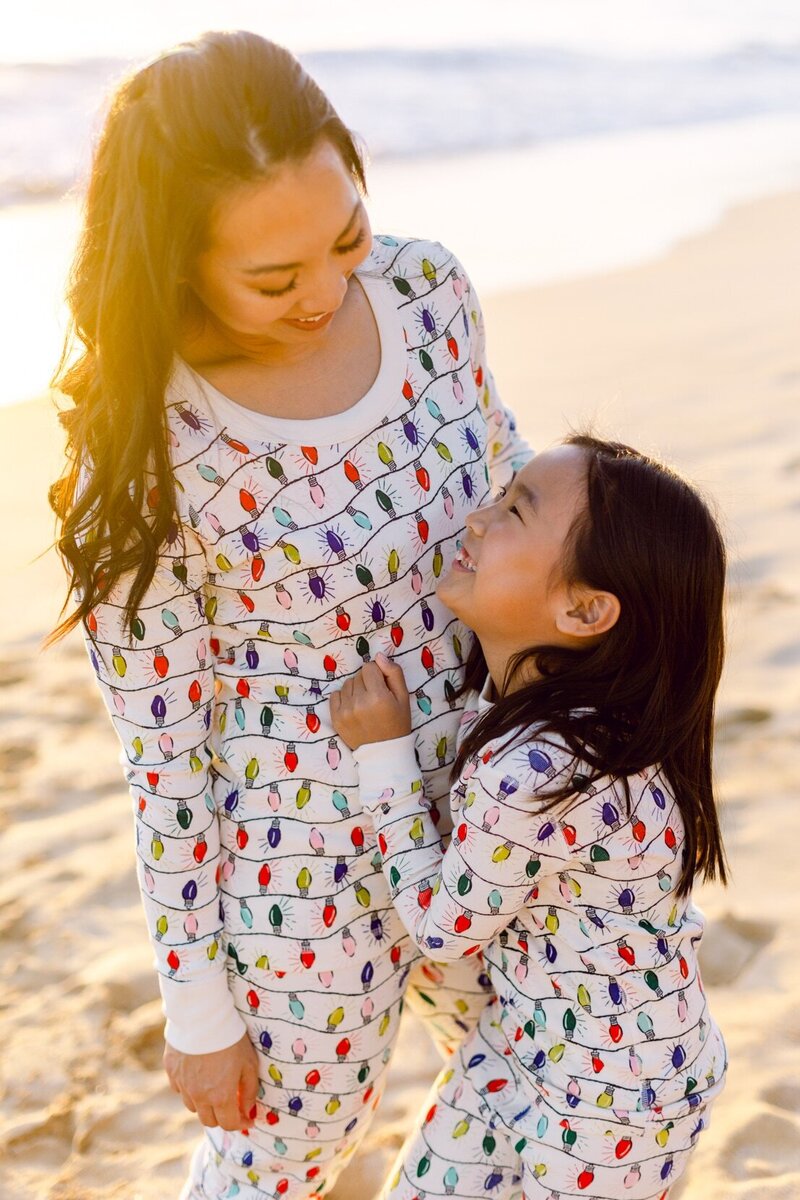 Maui Christmas mom and daughter at beach in Christmas pajamas