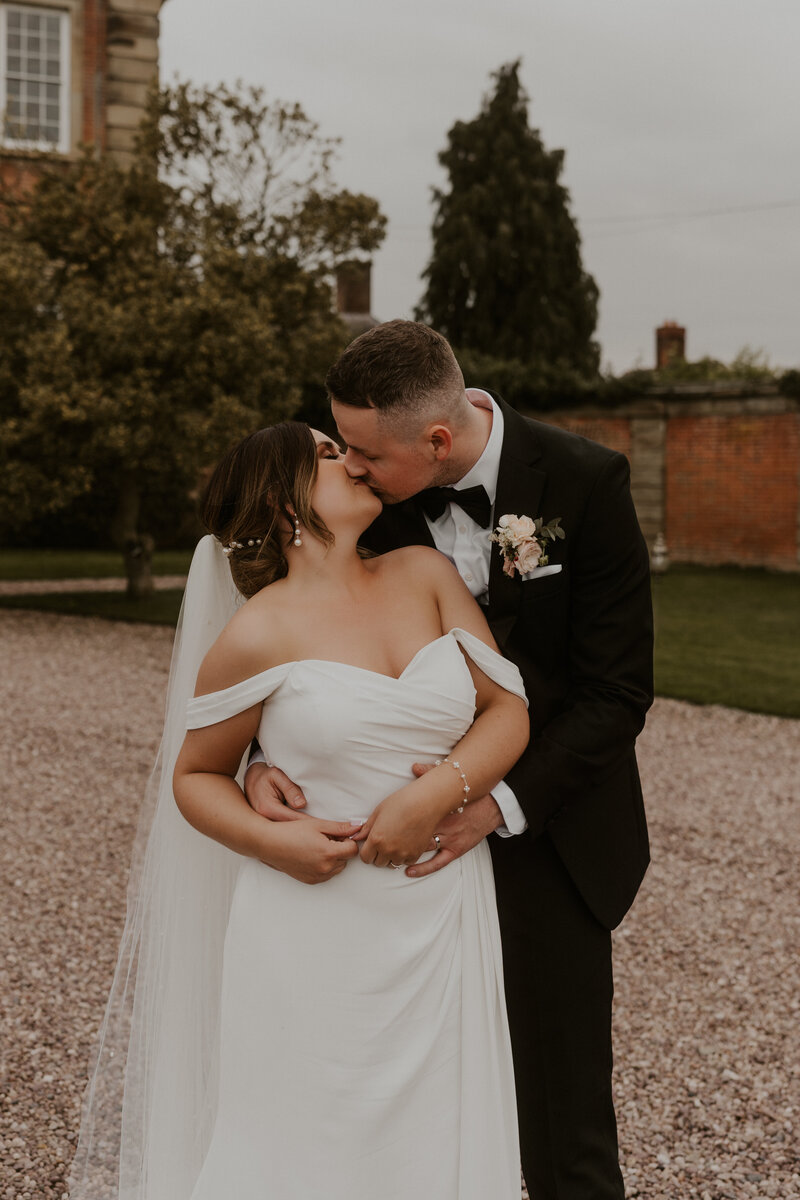 Black and White cinematic shot of newly married couple sharing a joyous and tender first kiss as husband and wife at Davenport House