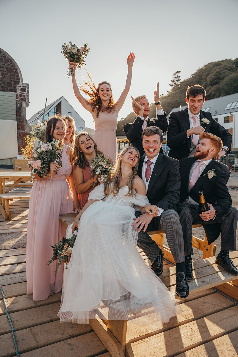 wedding party on bench in Salcombe harbour