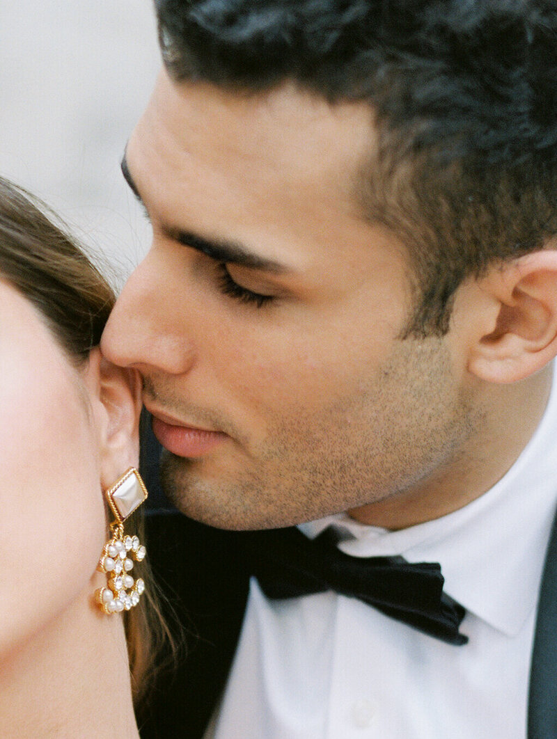 Groom kissing bride's ear