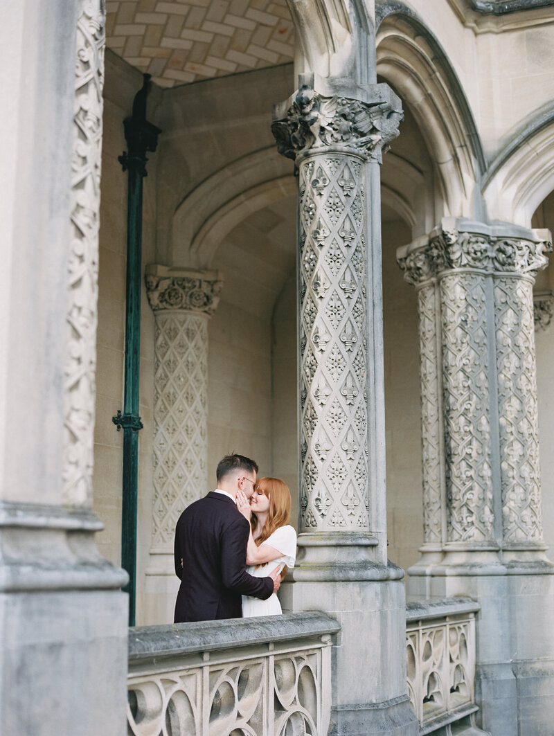 Bride and groom kissing next to pillar photographed by photography business coach Arielle Peters