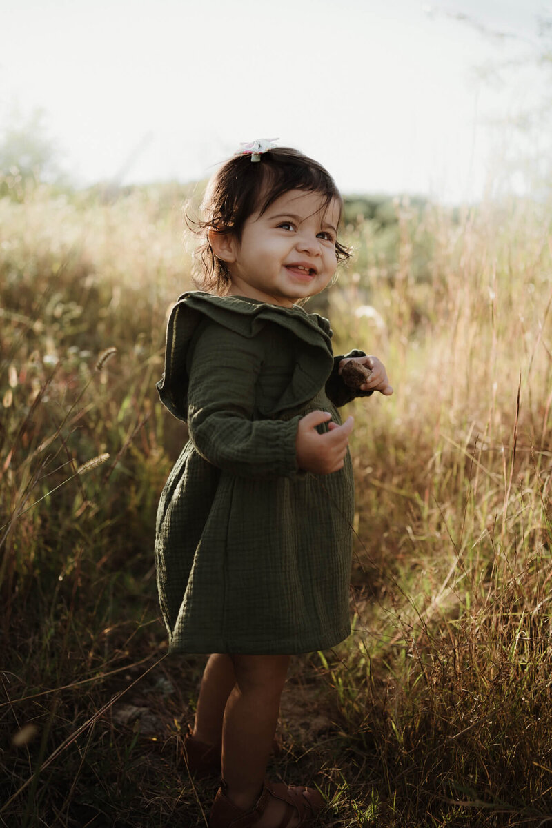 little girl in green dress smiling