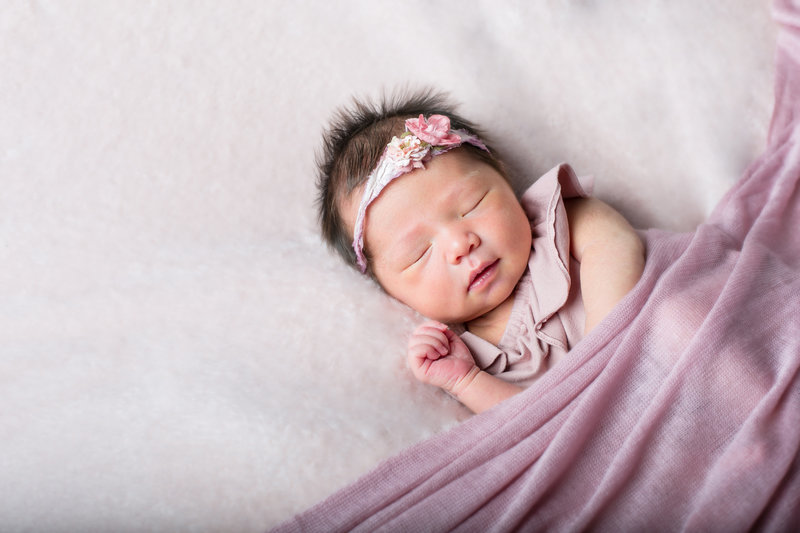 Newborn baby girl posing for portrait in Denver photography studio