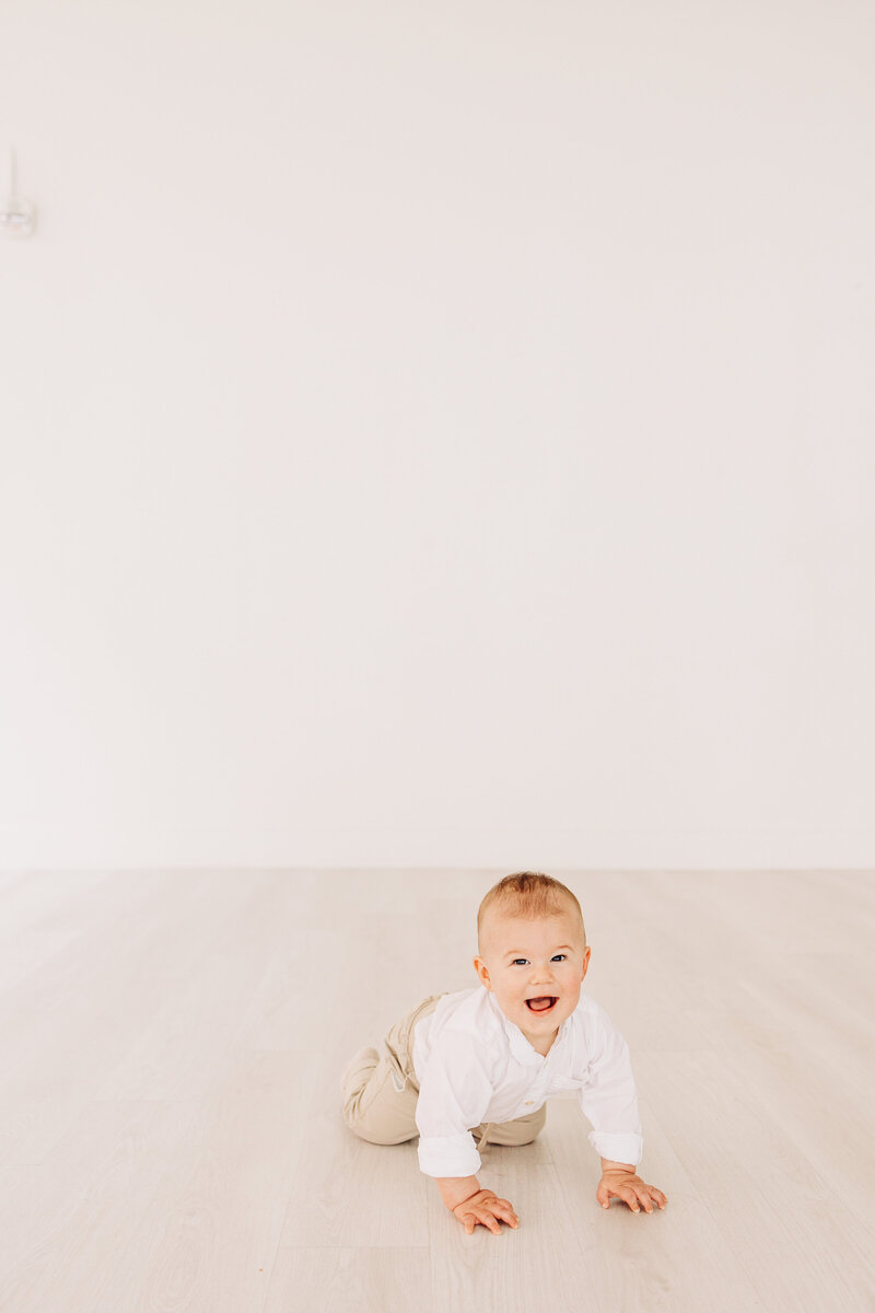 baby crawling and laughing during an indoor photography session