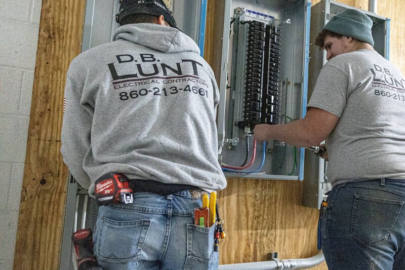Two Connecticut electricians installing a new panel for commercial building