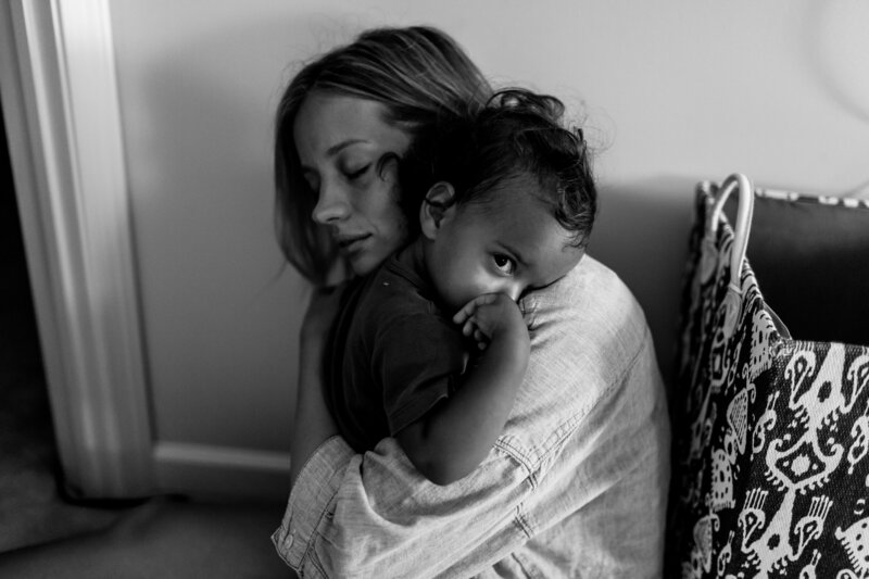 mom snuggling daughter during documentary family photography session in Denver, Colorado