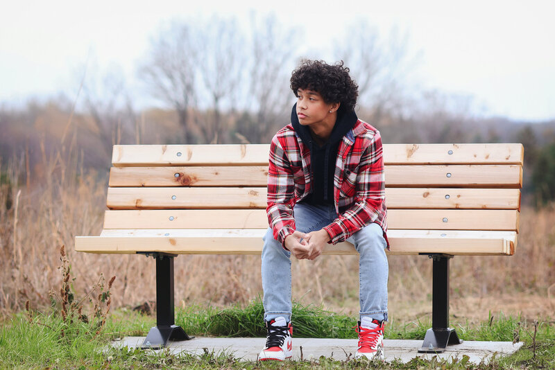 boy in plaid shirt on bench at park
