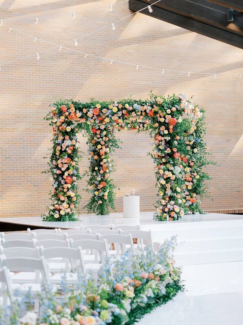 floral-filled chuppah on white stage with white chairs at Temple Israel in Memphis, TN