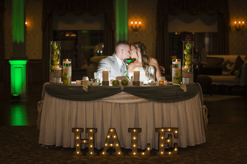 bride and groom share a kiss during the toasts