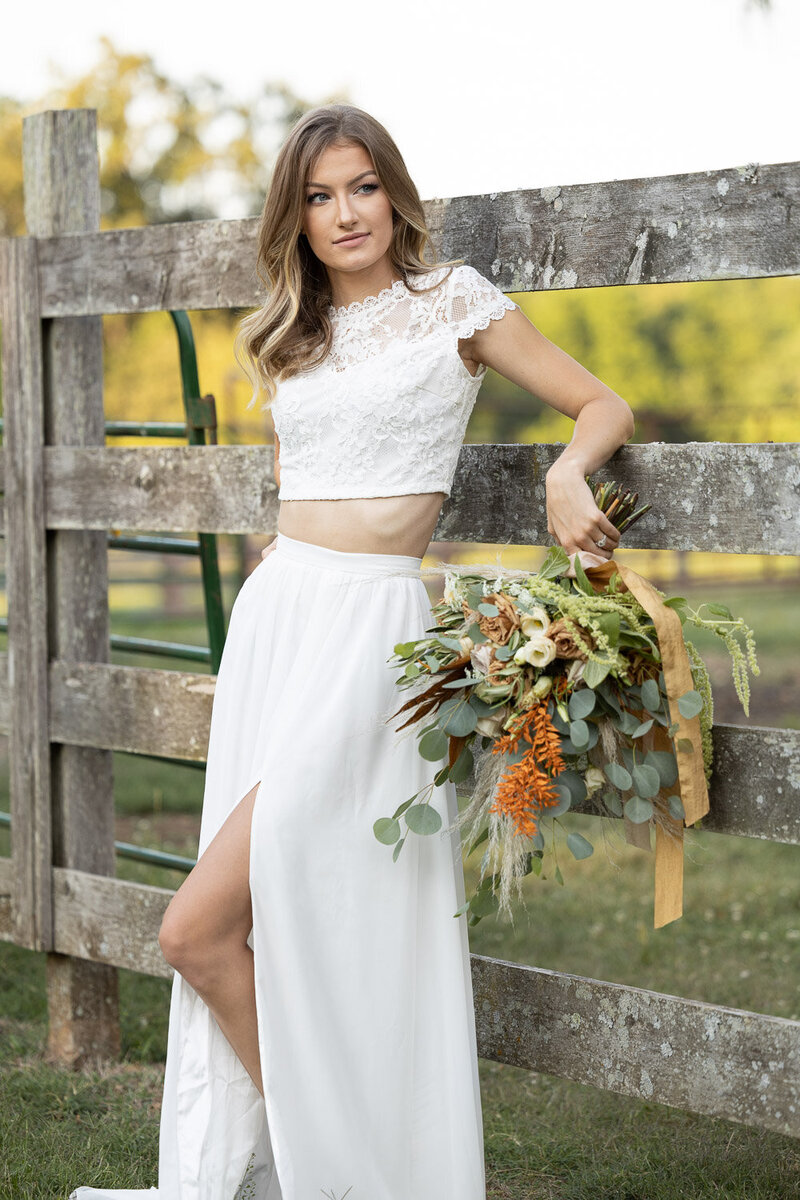 Bride in White dress holding a boquet on a farm during sunset photographed by Indianapolis wedding photographer