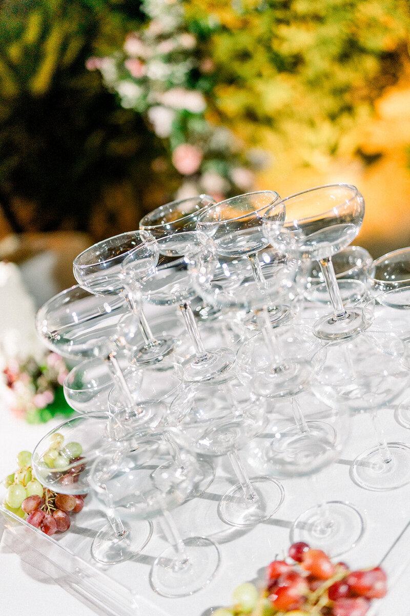 Editorial-style detail of coupe glasses stacked with fresh grapes at a wedding reception in Simi Valley California