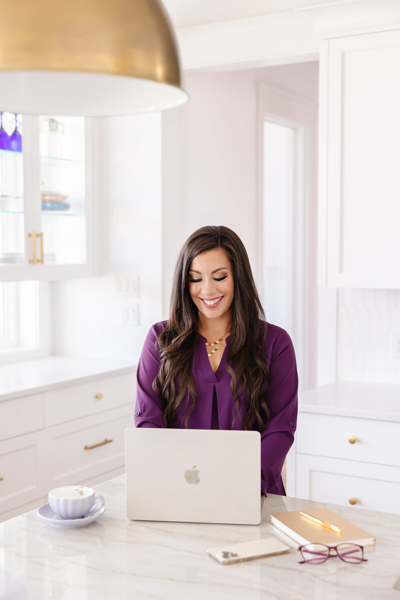 Monica Louie in a purple shirt working on Facebook and Instagram ads for clients
