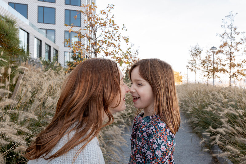 Family Photographer, happy mom and daughter smile nose to nose outdoors