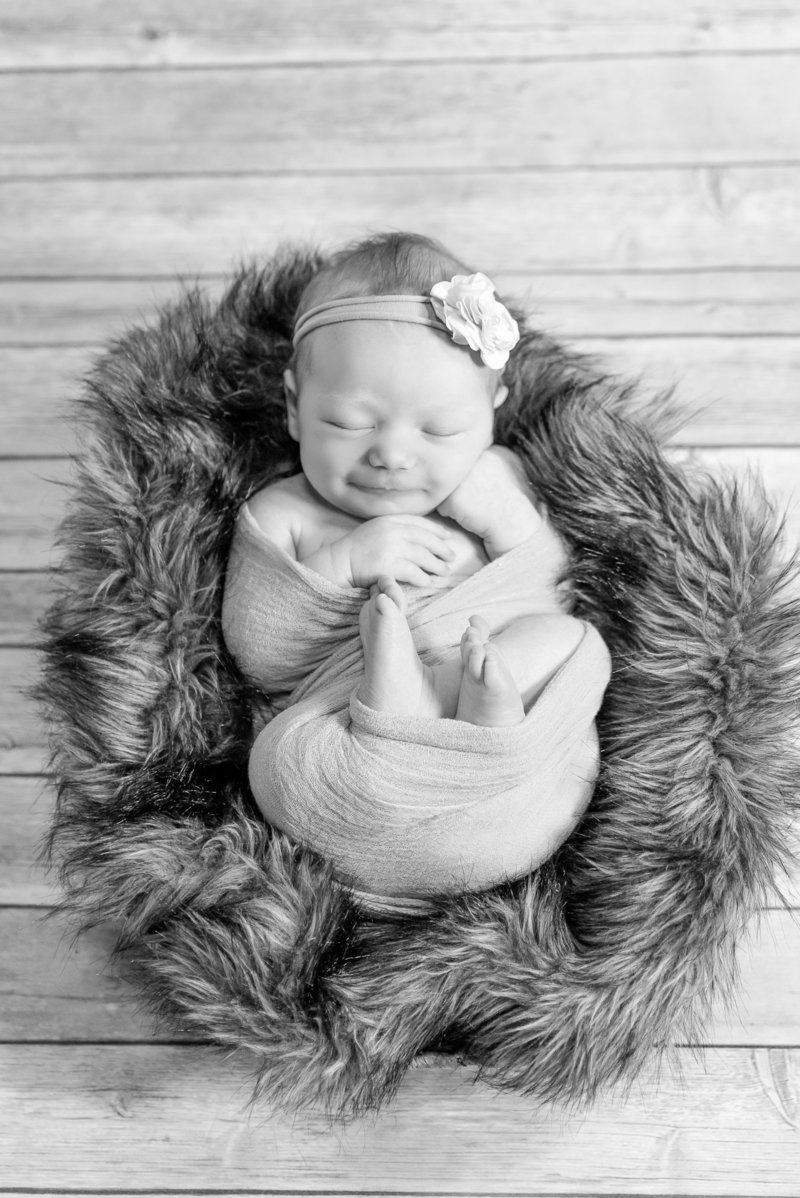 Black and white photo of a smiling newborn