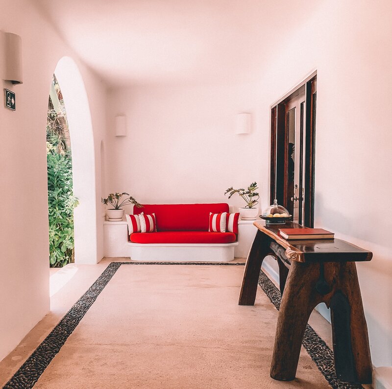 a bright red couch on a covered porch