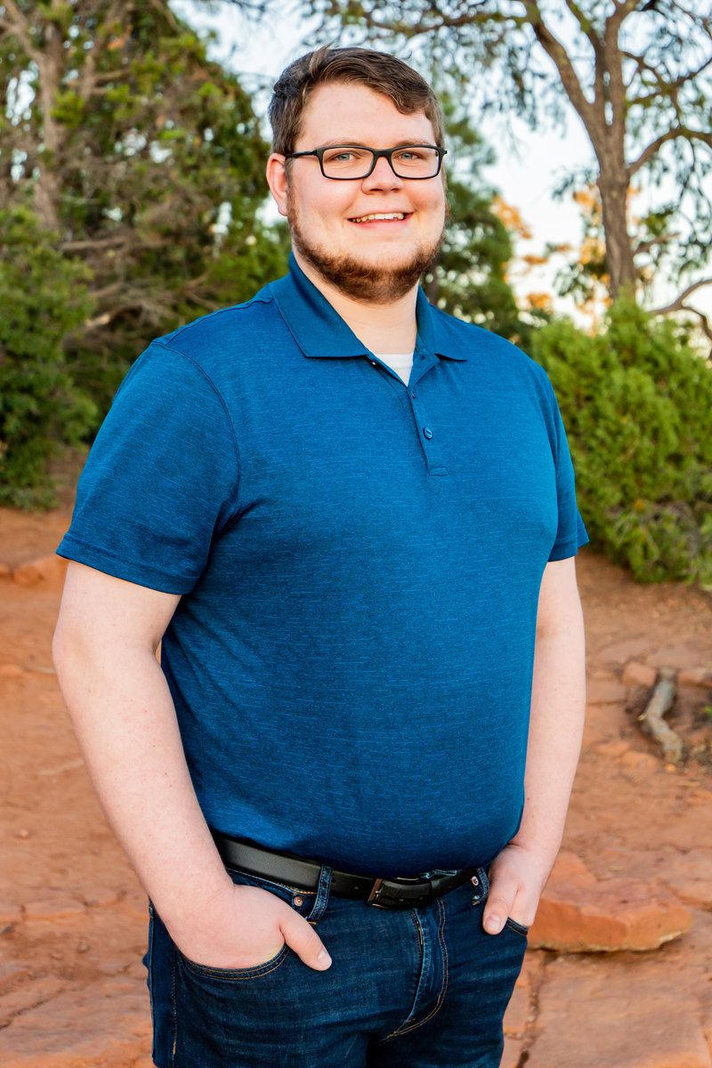 Tyler standing in front of trees at  Mogollon Rim