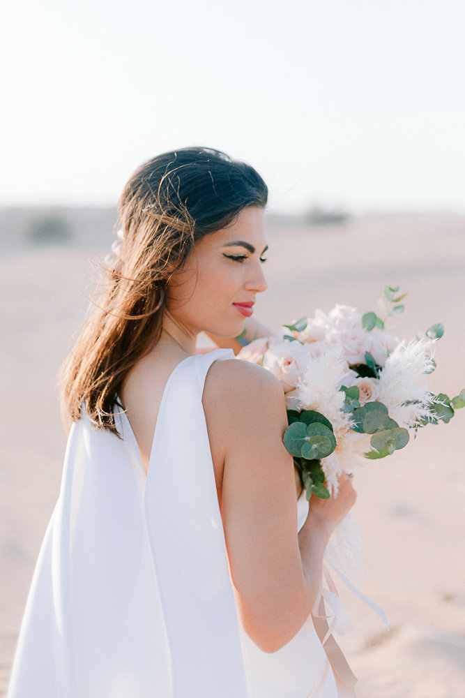 bride portrait with flower in the desert of Dubai in Emirat arab United