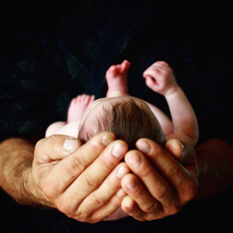 Newborn baby being held in hands