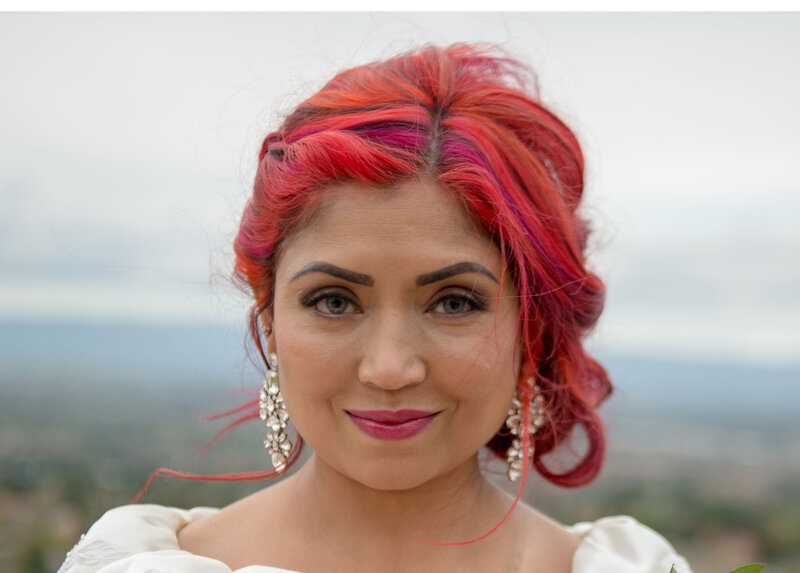 Timeless bridal makeup with a bright lip to match the brides bright colorful hair on a mixed race bride
