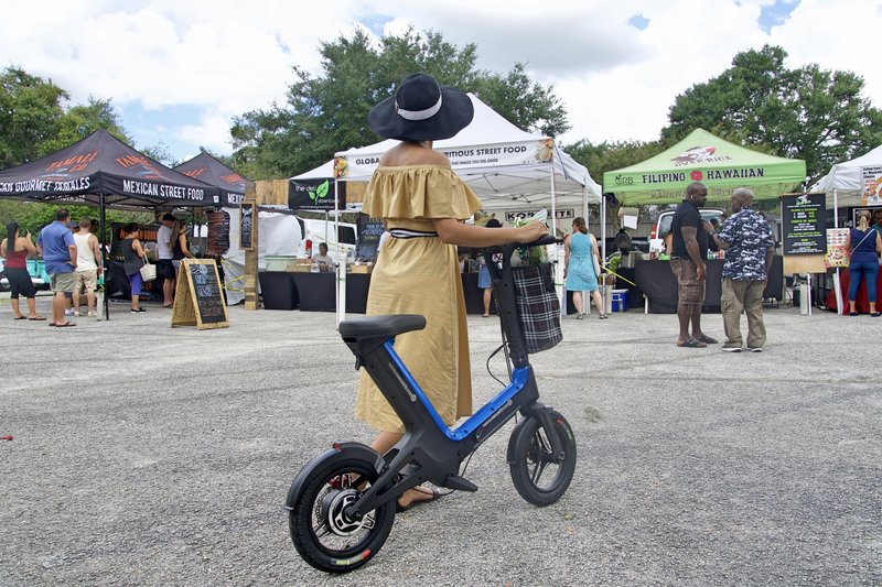 Lady with hat strolling with her Blue Go-Bike M3 at the farmers market. V&D Electric Bikes