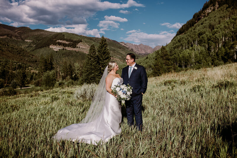 wedding couple standing in field in Colorado mountains