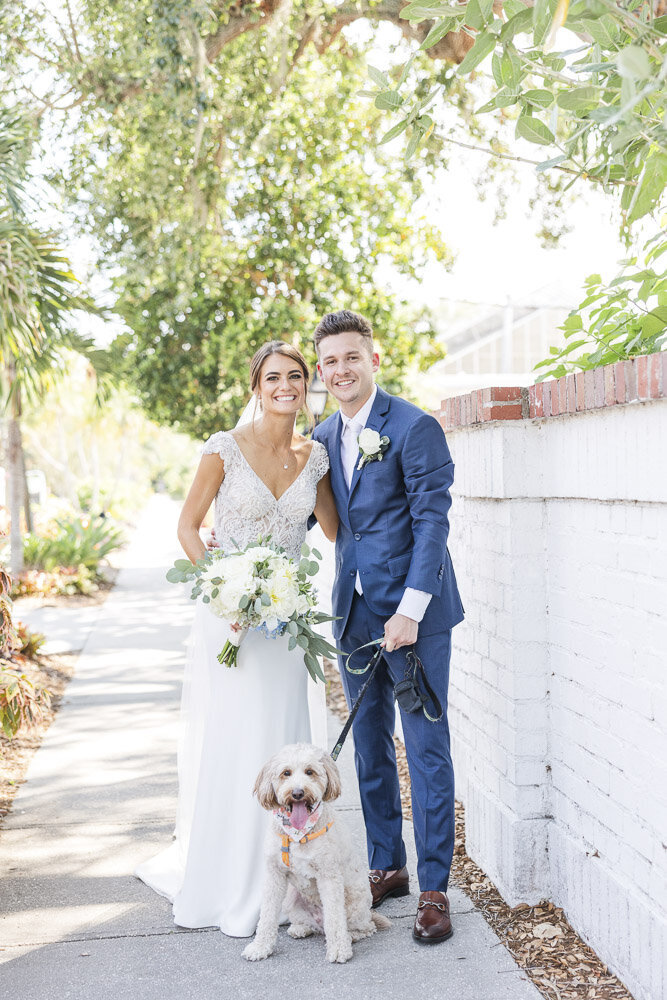bride and groom smiling with their dog