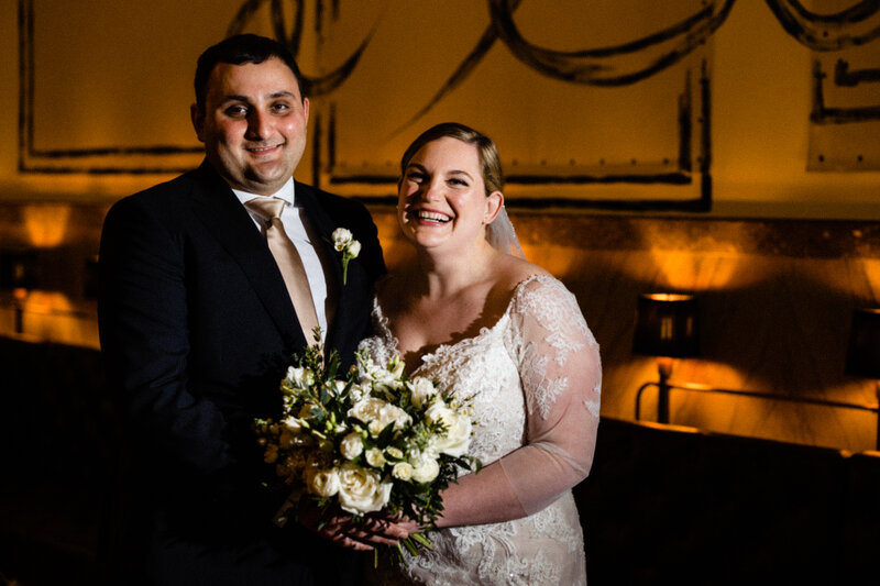 A wedding couple standing next to each other smiling.