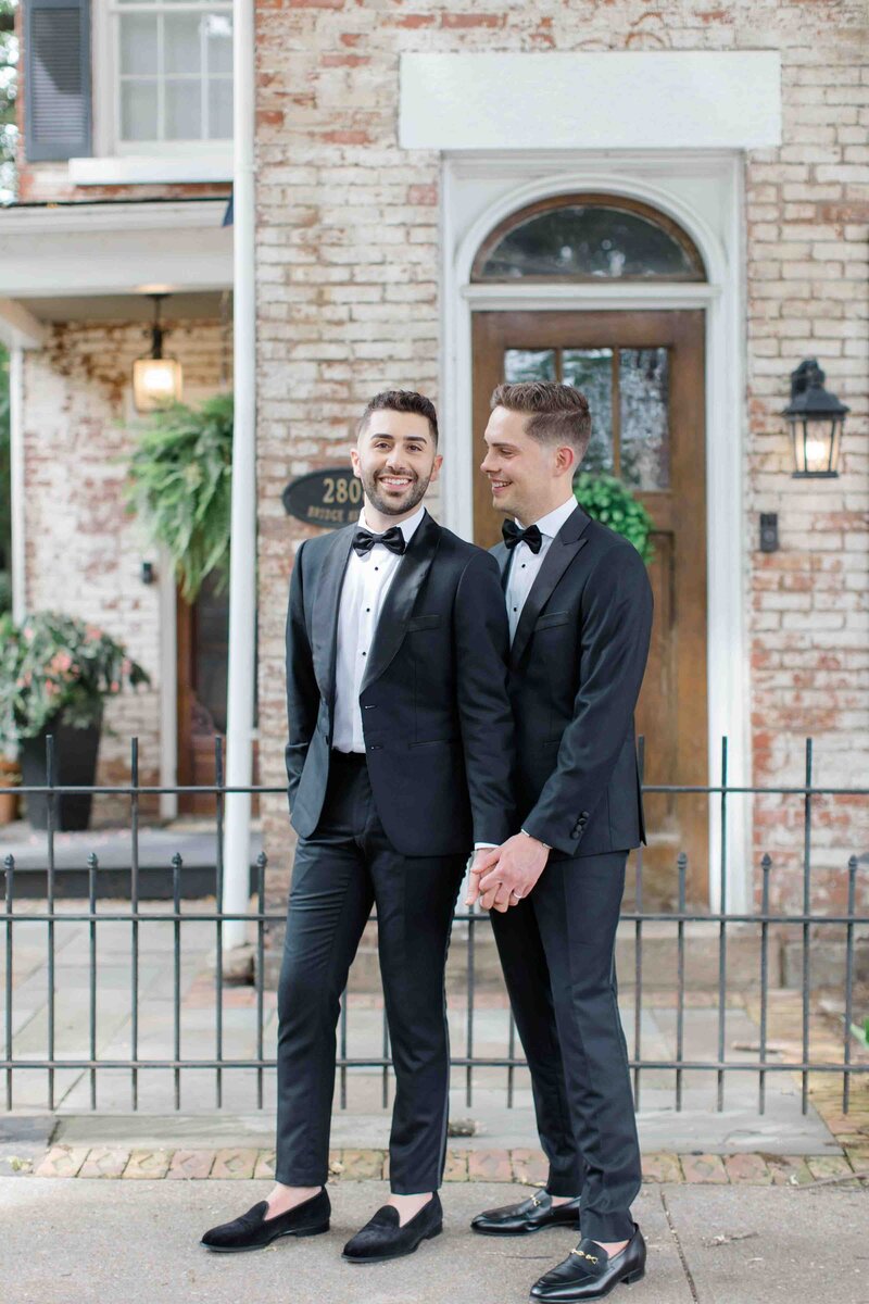 Two grooms holding hands smiling at each other on their wedding day in Cleveland Ohio