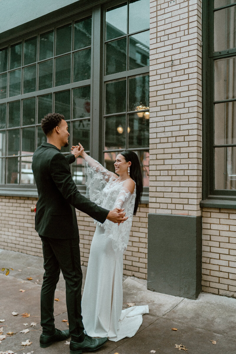 bride and groom holding hands during urban elopement