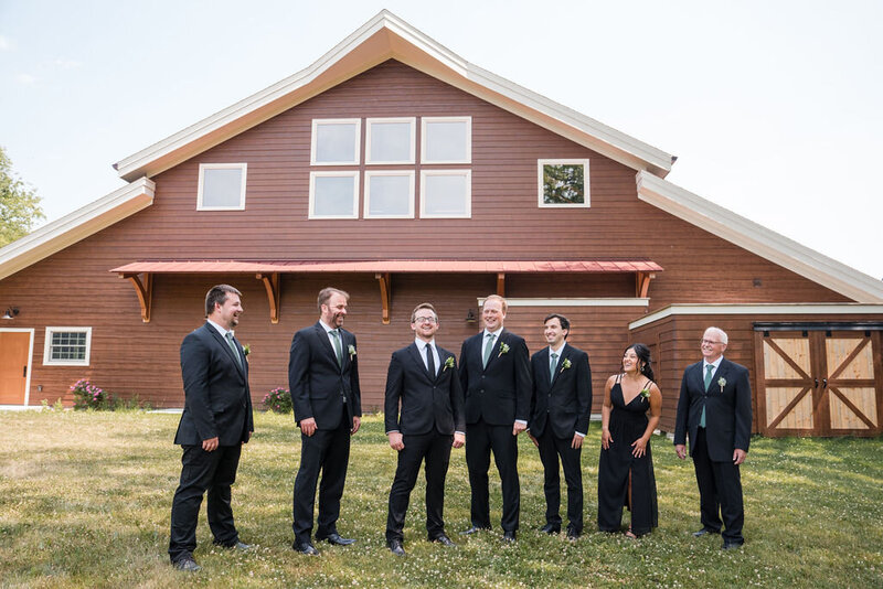 groomsmen striking a pose in the field of barnwood events, a wedding venue in madison, winconsin.