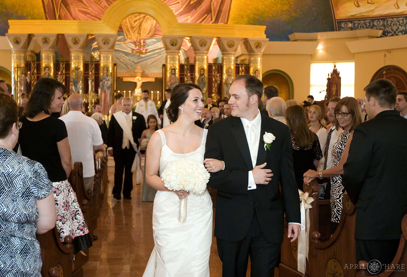 Married couple walk out of their Greek Orthodox wedding in Denver