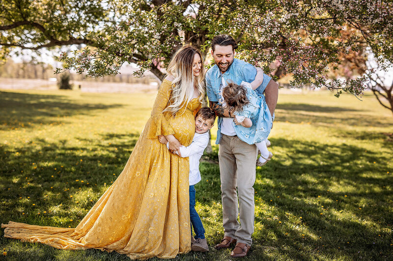 Pregnant women in yellow dress with husband and two kids