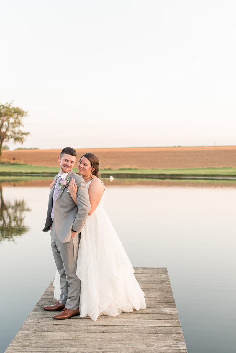 Bride and Groom standing on dock of pond