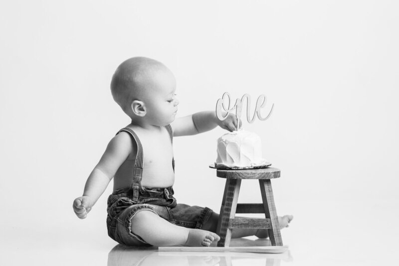 Baby touching cake for one year birthday, taken by cake smash photographer nj
