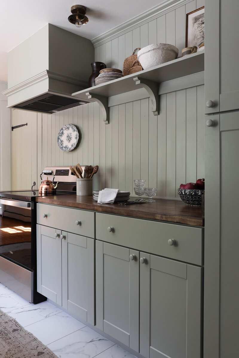 Laundry Room renovation by Nadine Stay. Rustic dark wood walls with basketweave brick floors. Brown door paint color. Mudroom built in cabinets.