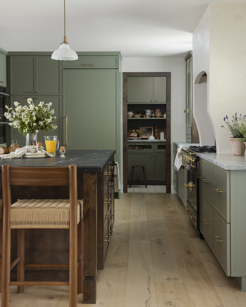 Orange county interior designer kitchen remodel. Painted cabinets with brass hardware, quartzite countertops, stained kitchen island with marble countertop and white oak wood floor.