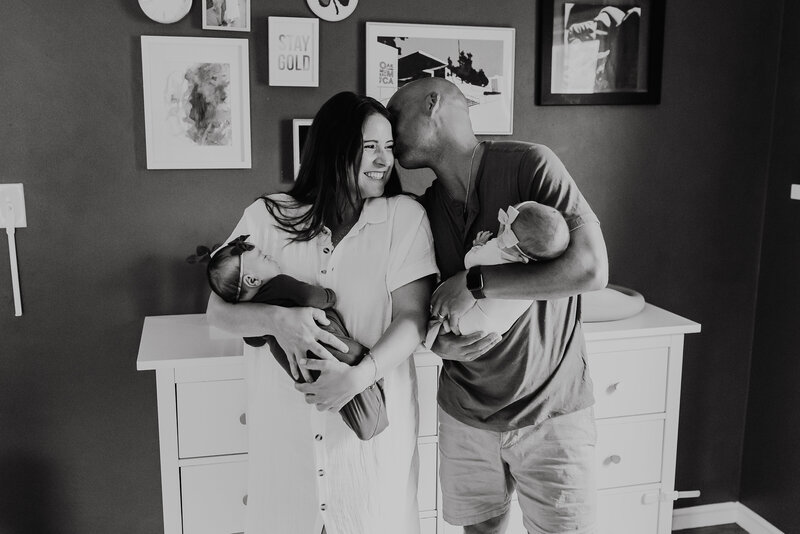 Mom and Dad hold twins in nursery Emily Woodall Photography