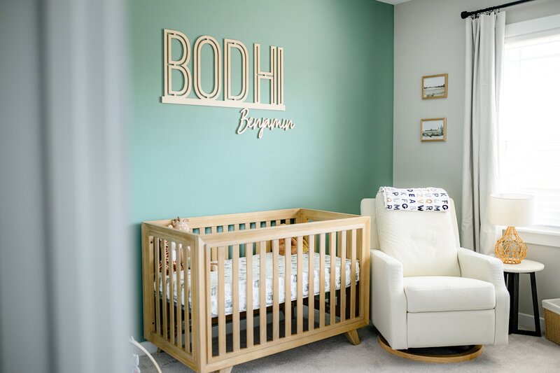 photo of accent wall in a newborn nursery with crib  and baby's name on the wall in wooden letters
