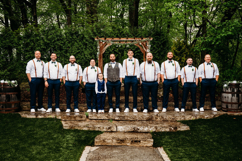 Groom and 9 groomsmen  and  ring bearer standing in a line